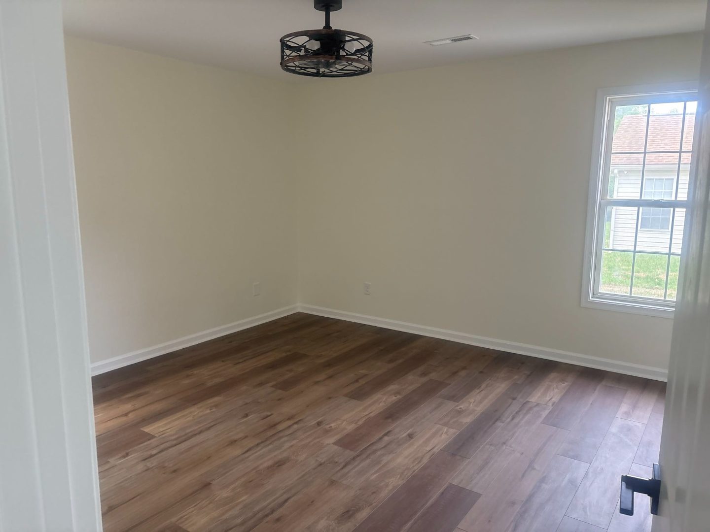 Bedroom with new wood floors and ceiling fan after renovation