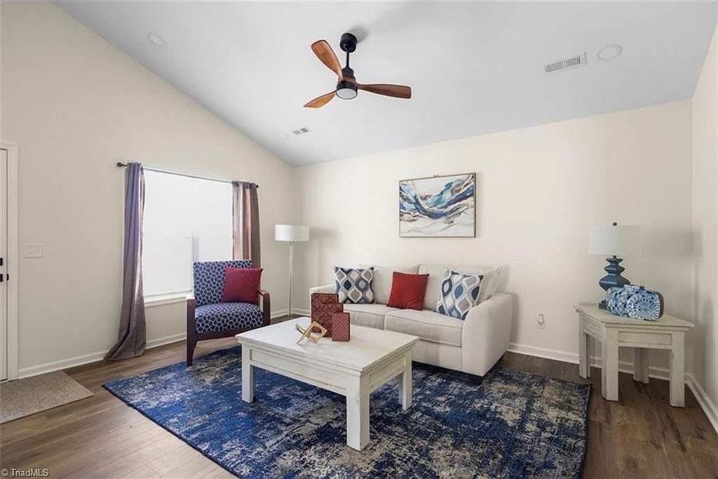 Staged living room with vaulted ceiling and new floors